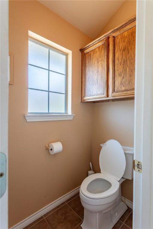 1701 Bradley Rd, College Station, TX 77845 - bathroom featuring tile patterned flooring, baseboards, toilet, and vaulted ceiling