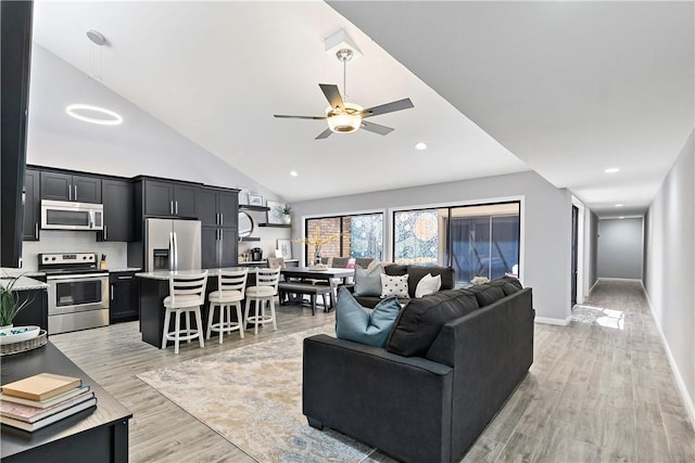 living room featuring light wood finished floors, baseboards, ceiling fan, high vaulted ceiling, and recessed lighting