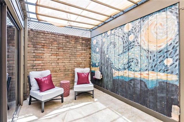 sitting room featuring unfinished concrete flooring and brick wall