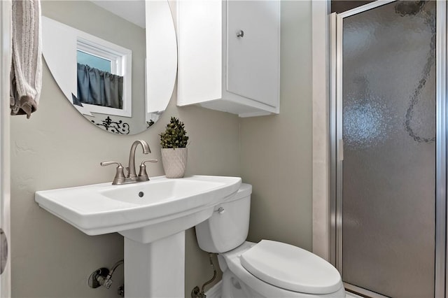 full bathroom featuring a sink, toilet, and a stall shower