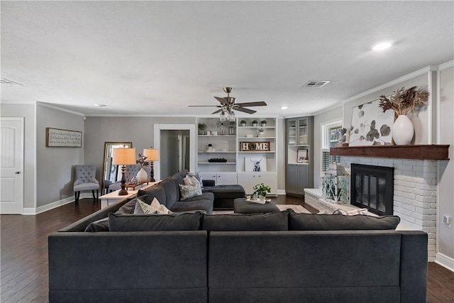 living area with ceiling fan, visible vents, dark wood finished floors, and crown molding