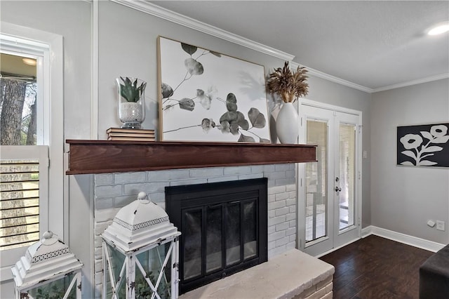 living room featuring dark wood-style floors, a brick fireplace, baseboards, and ornamental molding