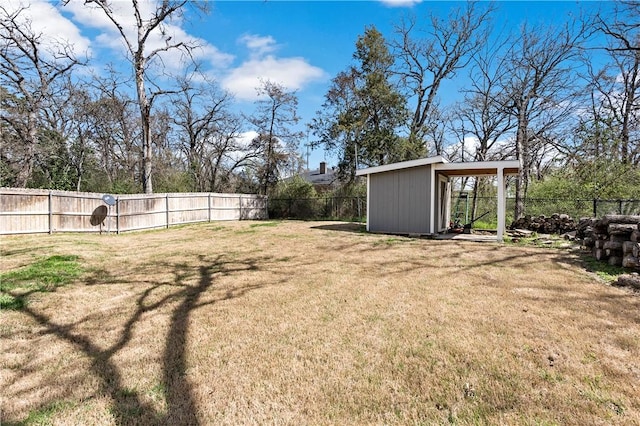 view of yard featuring an outbuilding, a fenced backyard, and a storage shed