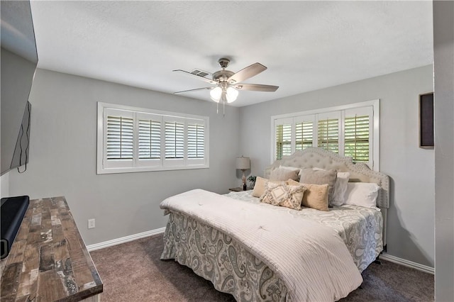 carpeted bedroom with visible vents, baseboards, and a ceiling fan