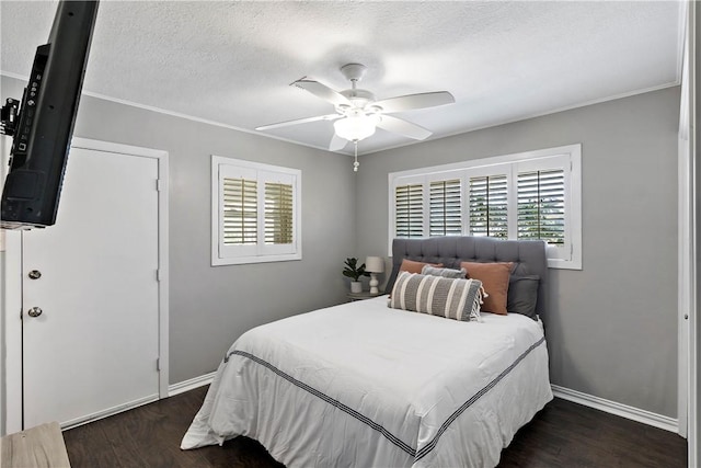 bedroom with dark wood-style floors, ceiling fan, a textured ceiling, and baseboards