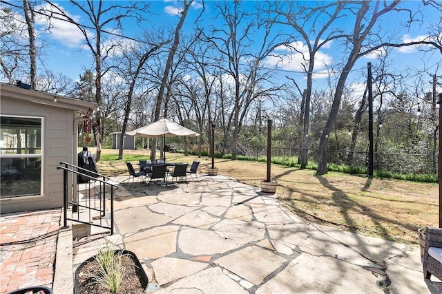 view of patio with outdoor dining area and fence