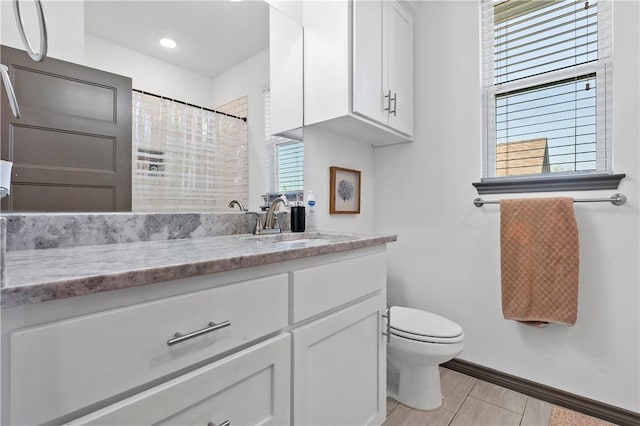 bathroom with vanity, toilet, walk in shower, and a wealth of natural light