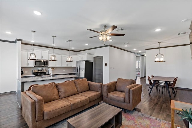 living room with crown molding, dark hardwood / wood-style flooring, ceiling fan with notable chandelier, and sink