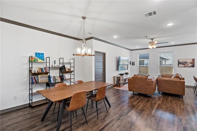 dining area with dark hardwood / wood-style floors, ornamental molding, and ceiling fan with notable chandelier