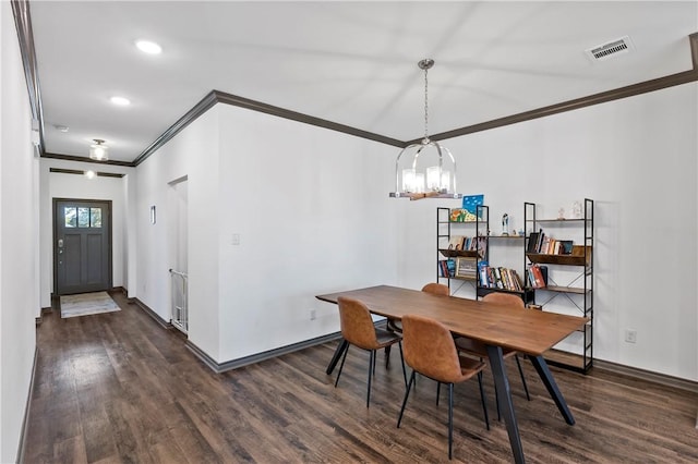 dining area featuring ornamental molding, dark wood-type flooring, and an inviting chandelier