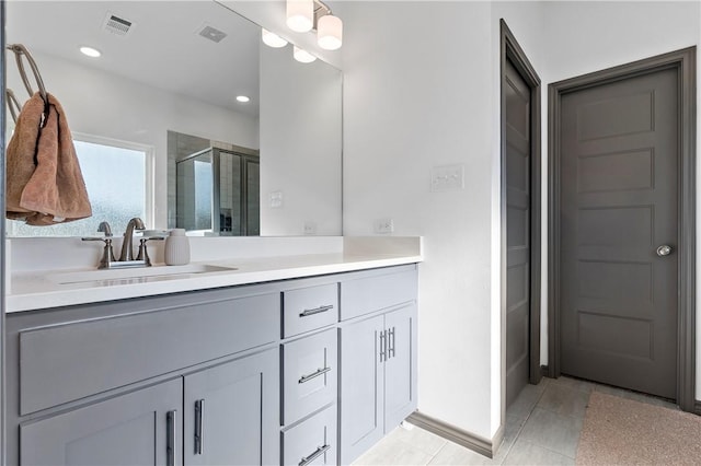 bathroom with tile patterned flooring, vanity, and an enclosed shower