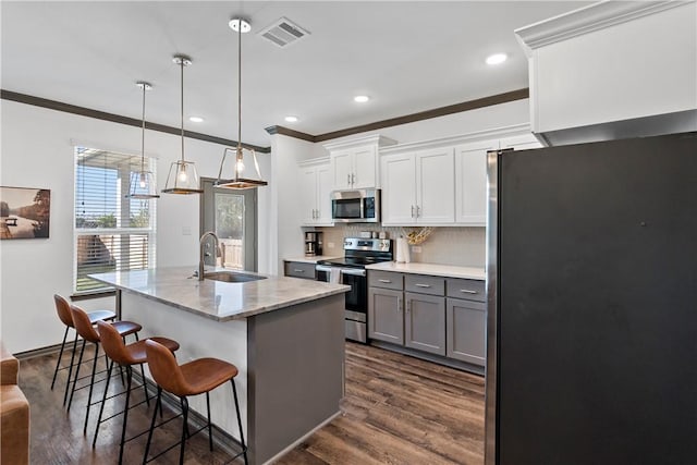 kitchen with white cabinetry, sink, stainless steel appliances, crown molding, and pendant lighting