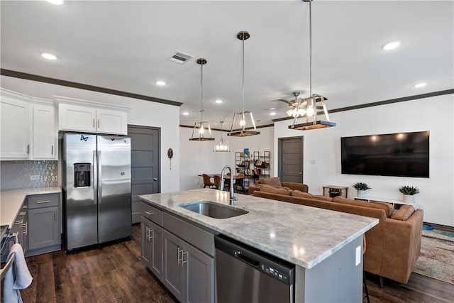 kitchen featuring appliances with stainless steel finishes, ornamental molding, sink, pendant lighting, and white cabinets