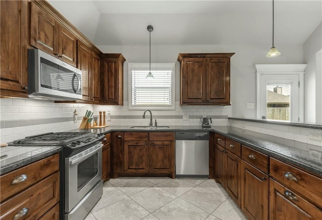 8305 Raintree Dr, College Station, TX 77845 - kitchen with appliances with stainless steel finishes, a sink, decorative backsplash, and decorative light fixtures