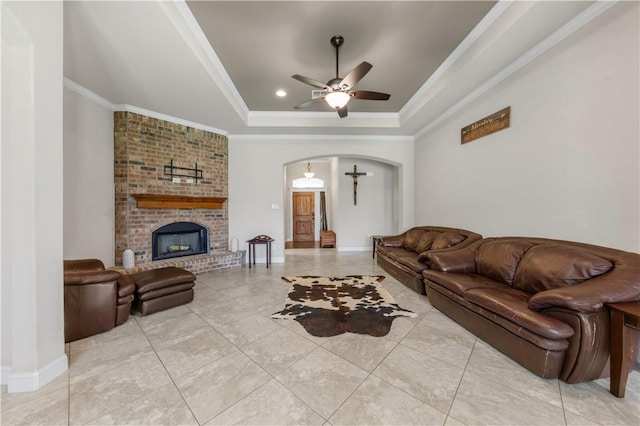 8305 Raintree Dr, College Station, TX 77845 - living room with a raised ceiling, arched walkways, a ceiling fan, ornamental molding, and baseboards