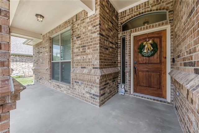 8305 Raintree Dr, College Station, TX 77845 - doorway to property with brick siding and a porch