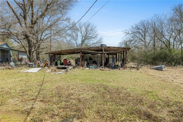 back of house featuring a yard, a pole building, and an outdoor structure