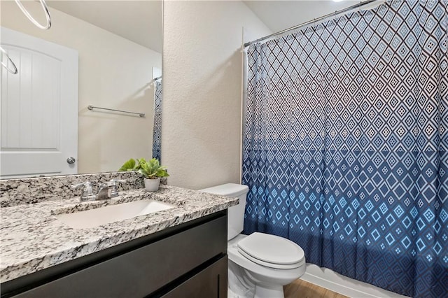 bathroom with hardwood / wood-style floors, vanity, and toilet