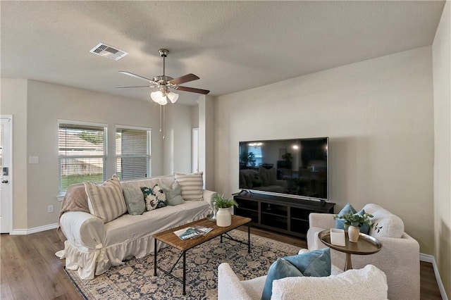 living room with hardwood / wood-style floors, a textured ceiling, and ceiling fan