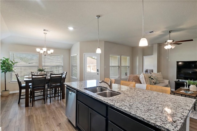 kitchen with sink, light hardwood / wood-style flooring, stainless steel dishwasher, an island with sink, and decorative light fixtures