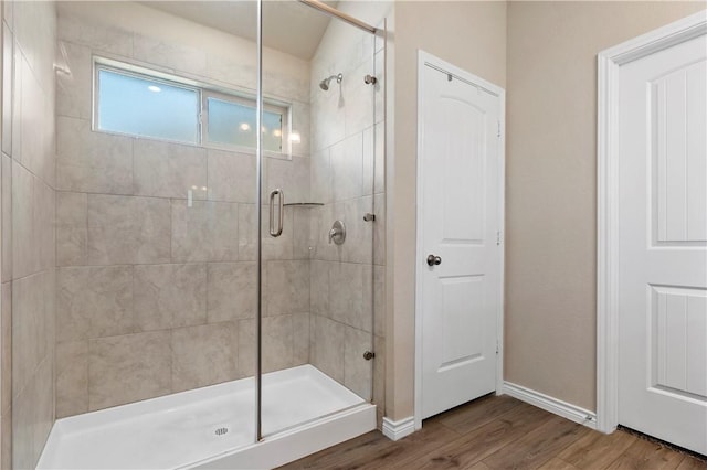 bathroom with hardwood / wood-style floors and a shower with shower door