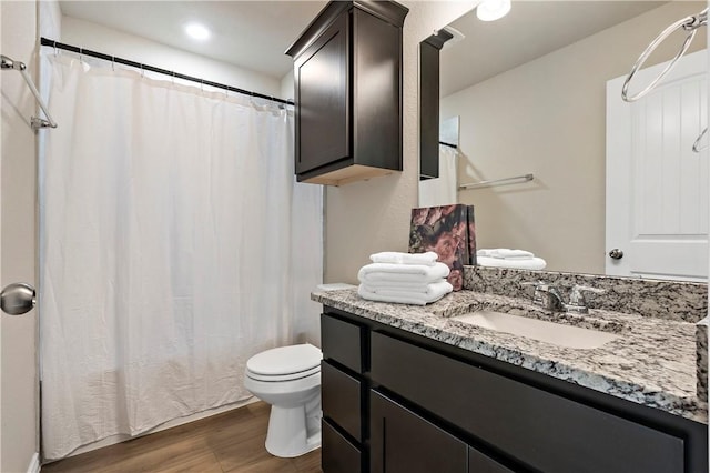 bathroom with vanity, hardwood / wood-style flooring, and toilet