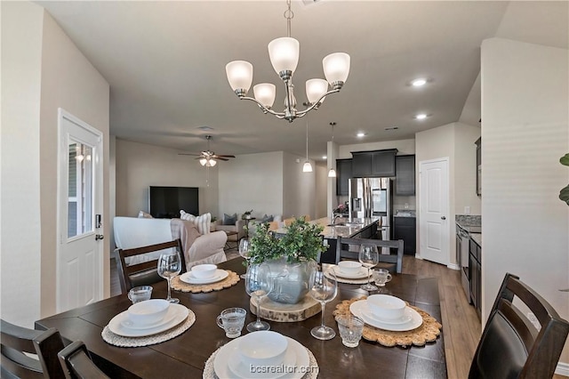 dining area featuring dark hardwood / wood-style floors and ceiling fan with notable chandelier