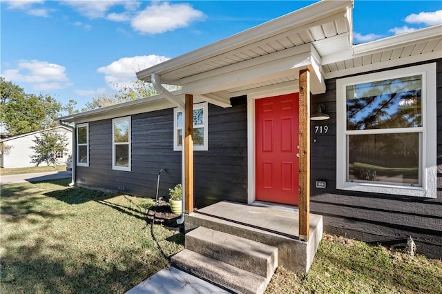 entrance to property with a lawn