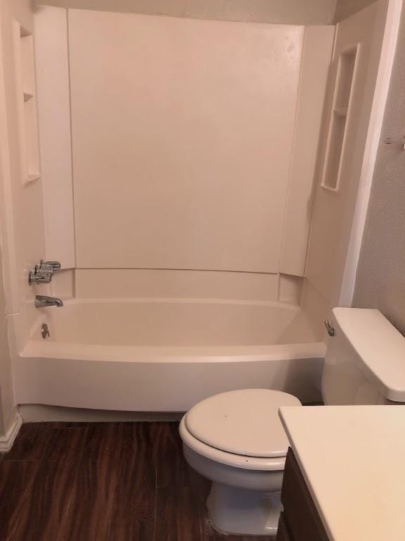 full bathroom with wood finished floors, shower / tub combination, vanity, and toilet