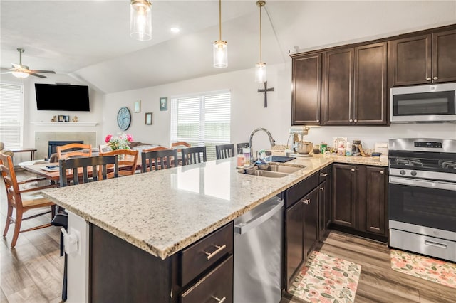 7906 Putter Pl, Navasota, TX 77868 - kitchen with stainless steel appliances, a sink, lofted ceiling, a ceiling fan, and light wood finished floors