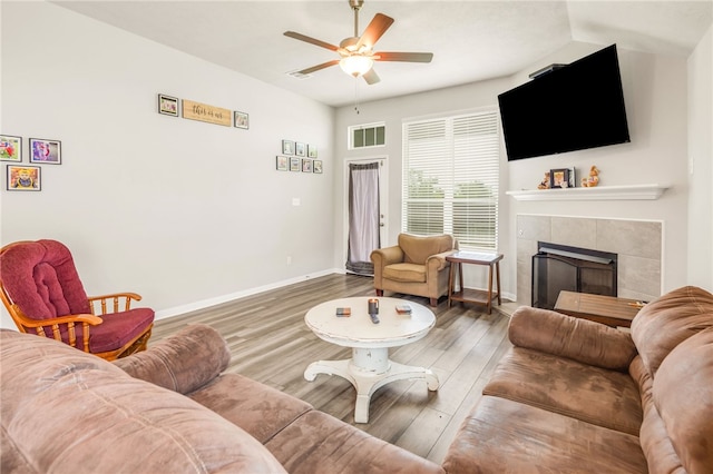 7906 Putter Pl, Navasota, TX 77868 - living area featuring a tile fireplace, a ceiling fan, wood finished floors, and baseboards