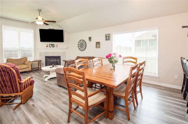 7906 Putter Pl, Navasota, TX 77868 - dining room with a ceiling fan, a tiled fireplace, light wood finished floors, healthy amount of natural light, and lofted ceiling