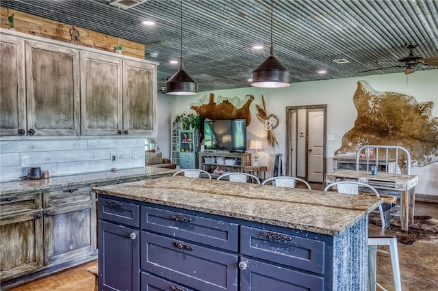 1850 Lcr 439, Groesbeck, TX 76667 - kitchen featuring a kitchen island, blue cabinetry, pendant lighting, light stone countertops, and ceiling fan