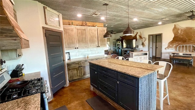 kitchen featuring a center island, black range with gas stovetop, light stone counters, pendant lighting, and a breakfast bar