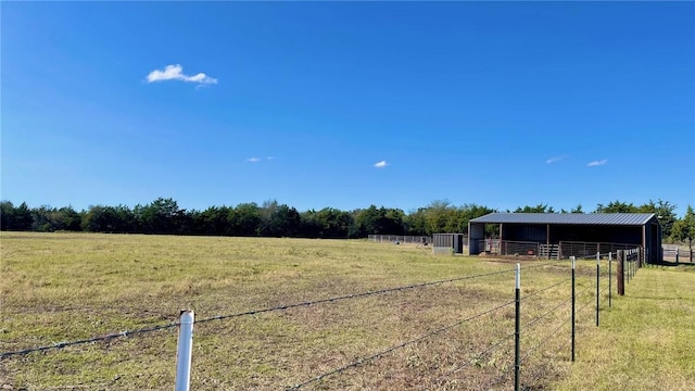 view of yard with a rural view and an outdoor structure