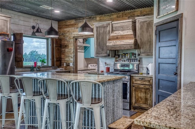 1850 Lcr 439, Groesbeck, TX 76667 - kitchen with stainless steel gas range, light stone counters, a kitchen bar, a kitchen island, and recessed lighting