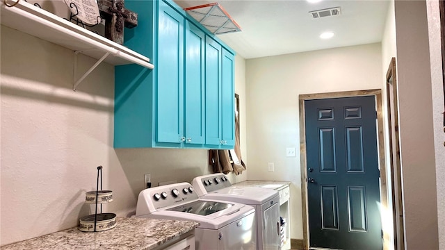 laundry room featuring separate washer and dryer and cabinets