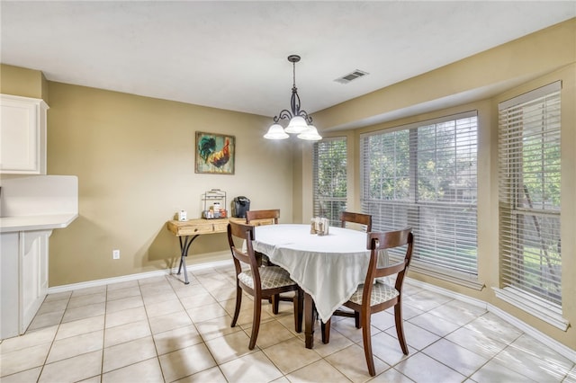 dining area with a notable chandelier and light tile patterned flooring