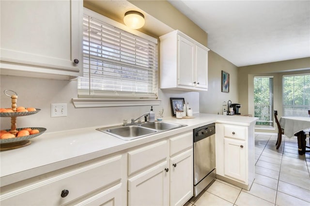 kitchen featuring dishwasher, white cabinets, sink, light tile patterned flooring, and kitchen peninsula