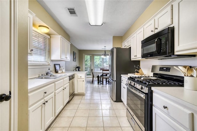 kitchen with appliances with stainless steel finishes, sink, light tile patterned floors, pendant lighting, and white cabinetry