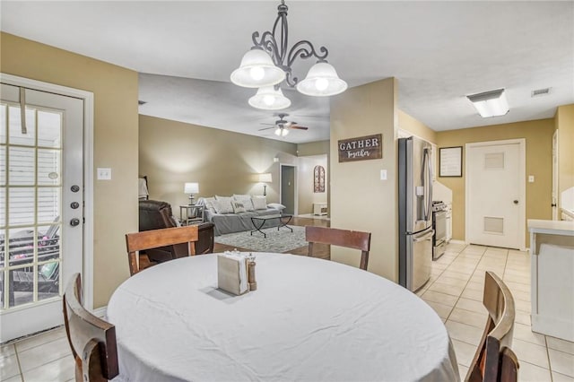 tiled dining space featuring ceiling fan with notable chandelier and a healthy amount of sunlight