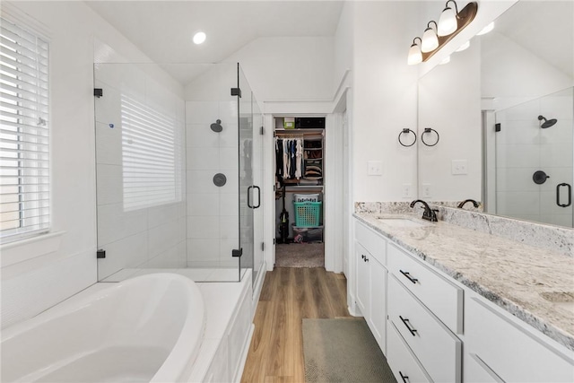 bathroom with hardwood / wood-style flooring, vanity, independent shower and bath, and vaulted ceiling