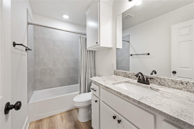 full bathroom featuring vanity, toilet, hardwood / wood-style floors, and shower / bath combo with shower curtain