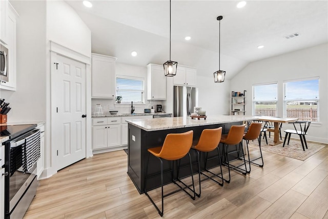 kitchen featuring stainless steel appliances, a center island, and white cabinets