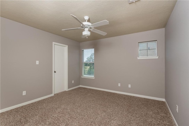 carpeted empty room with a textured ceiling, baseboards, and a ceiling fan