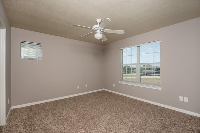 unfurnished room featuring a textured ceiling, carpet flooring, a ceiling fan, and baseboards