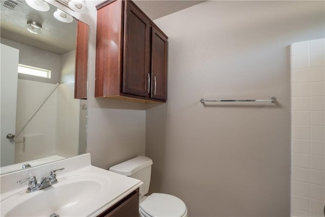 bathroom with toilet, vanity, and visible vents