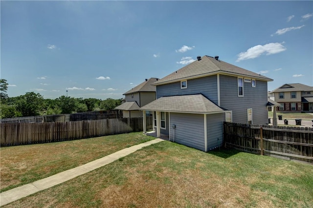 back of property featuring a lawn and a fenced backyard