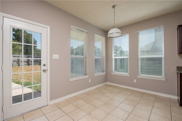 unfurnished dining area with a wealth of natural light and baseboards