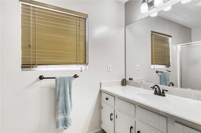 full bathroom with baseboards, an enclosed shower, and vanity